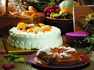 round cake with fruits on top near chocolate cake