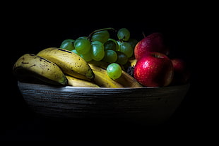 photo of ripe bananas,green grapes and red apples in brown basket