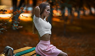 woman wearing white short-sleeved crop top and pink skirt sitting on yellow and green chair during daytime HD wallpaper