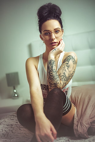 woman wearing white tank top with left arm tattoos