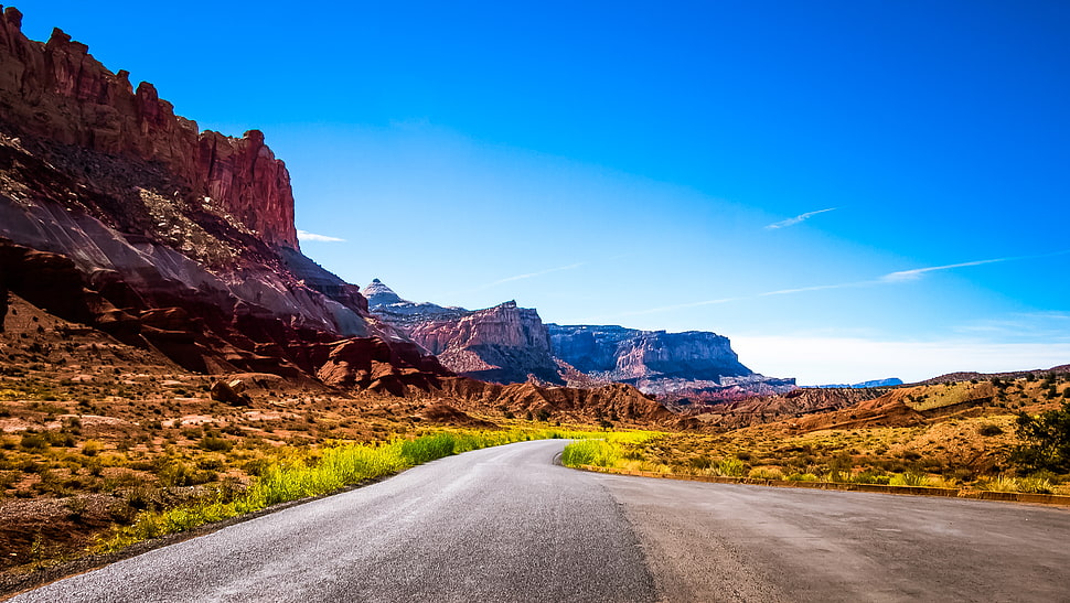 highway near rock formations at daytime HD wallpaper