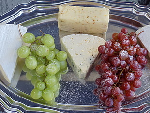 cheese cake, white, and red grapes on tray