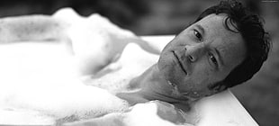 grayscale photography of man in bathtub