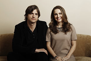 couple sitting on brown sofa HD wallpaper