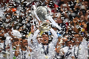 man wearing white Fly Emirates long sleeve shirt carrying trophy beside group of men HD wallpaper