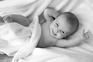 baby boy smiling photo on white textile