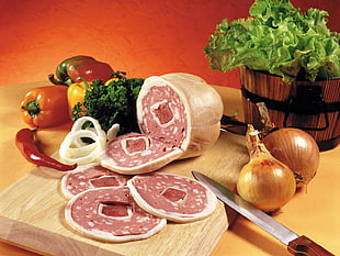 slice ham on surrounded with spices on chopping board