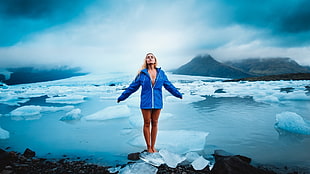 fish eye lens photography of woman wearing blue zip-up jacket standing on cracked ice near body of water HD wallpaper