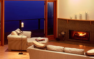 brown electronic fire pit front of two brown fabric sofa and sofa chair