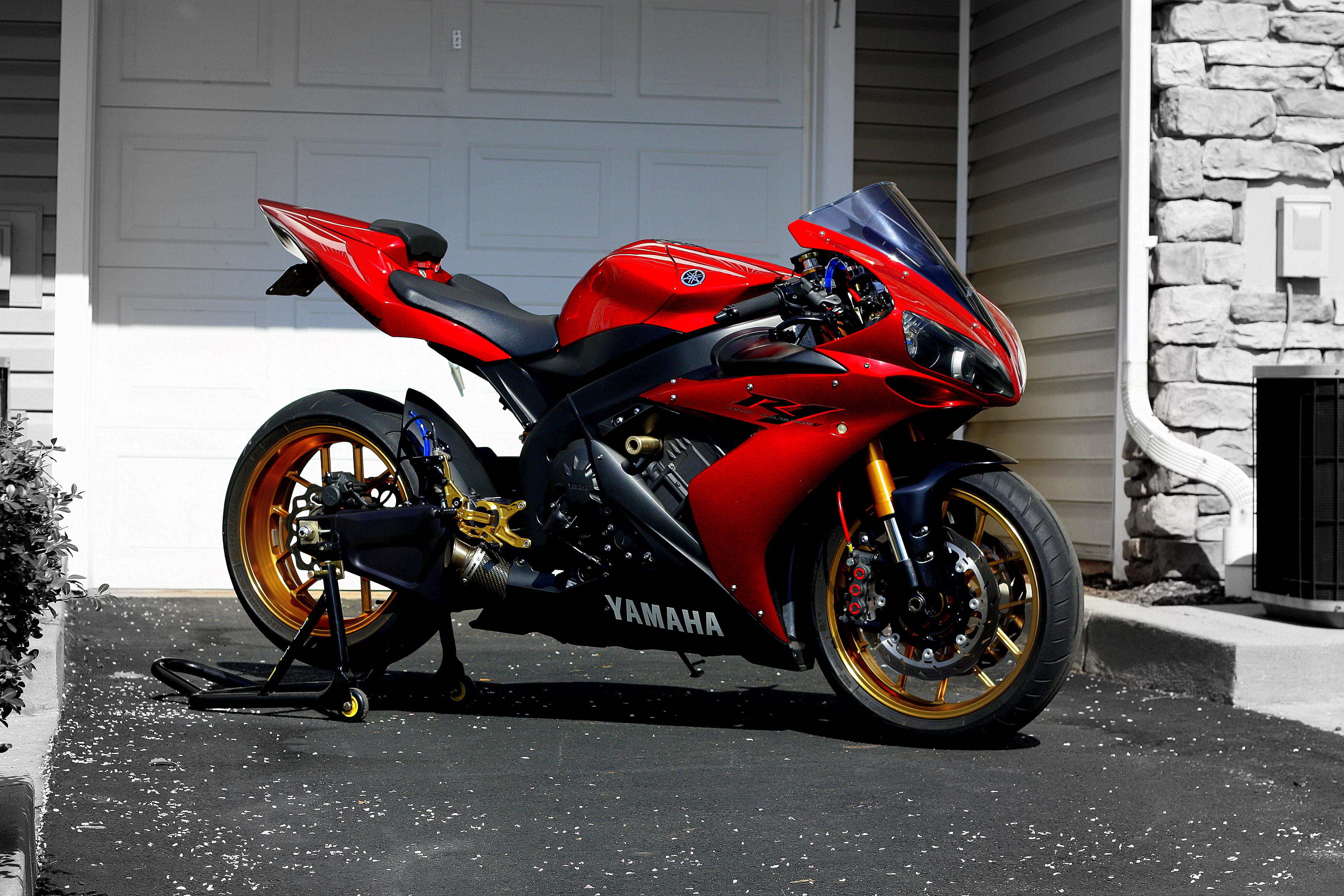 Red and black Yamaha sport bike near white painted garage door HD