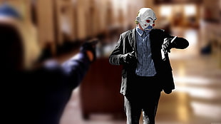 person wearing clown mask while holding pistol