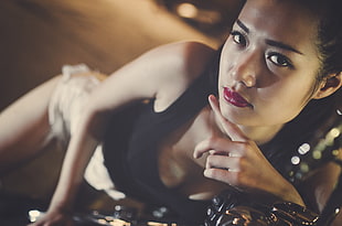 woman wearing black tank top and lying on the motorcycle