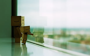 shallow depth of field photo of two danboards on clear glass wall