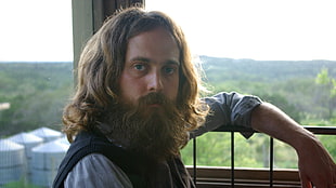 brown-haired man sitting near a balcony bar HD wallpaper