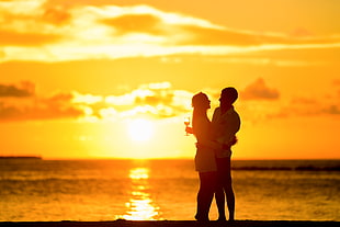 Couple Standing in the Seashore Hugging Each Other during Sunset HD wallpaper