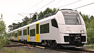 white and yellow train on rail road