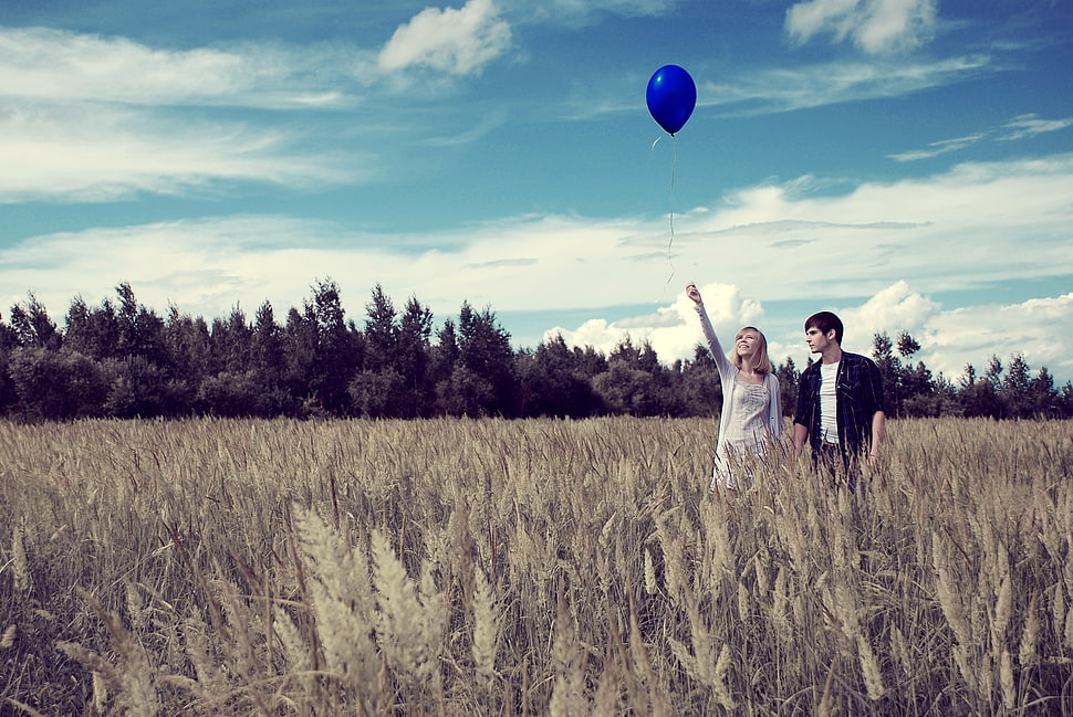 couple walking on brown grass field under blue sky during daytime HD wallpaper