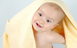 yellow blanket covering baby's head and right shoulder