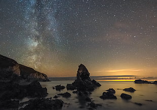 rock formations on beach under starry dusk sky, porth