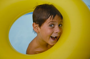 boy holding yellow inflatable ring