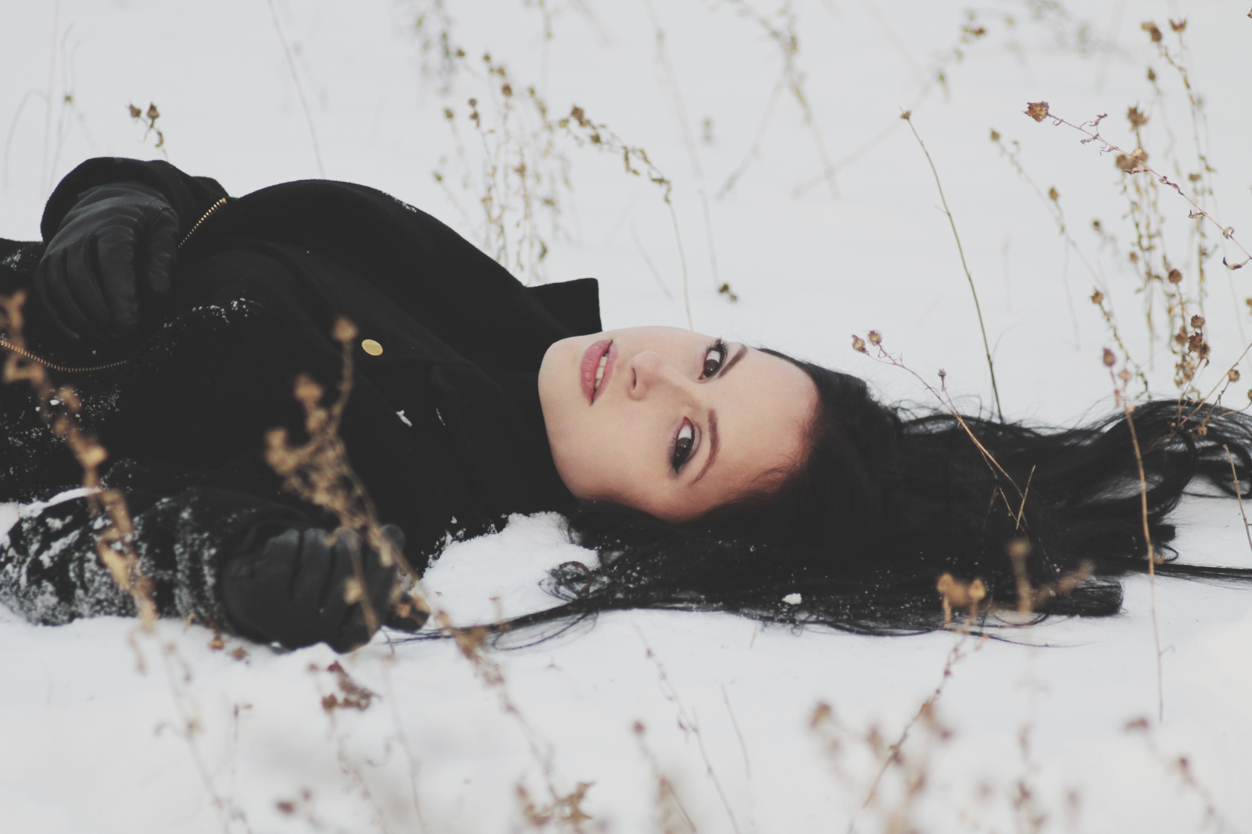 woman lying, wearing black trench coat