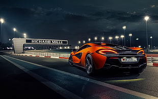 orange and black McLaren on racing track HD wallpaper
