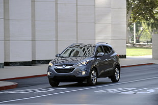 gray hyundai suv on asphalt road with stop signage near concrete building during daytime HD wallpaper
