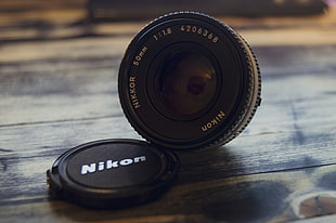 macro shot photography of black Nikon camera lens and cover