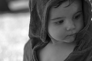 grey scale photo of baby in jacket