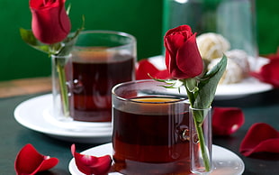 clear tea glasses and red roses