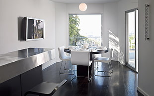photo of black wooden dining table with white chairs