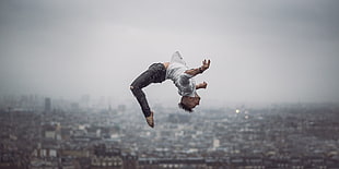 man black flipping above buildings, ballet, jumping, Paris, backflip