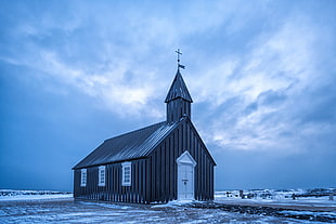 Church covered with snow under blue and white cloudy sky, iceland