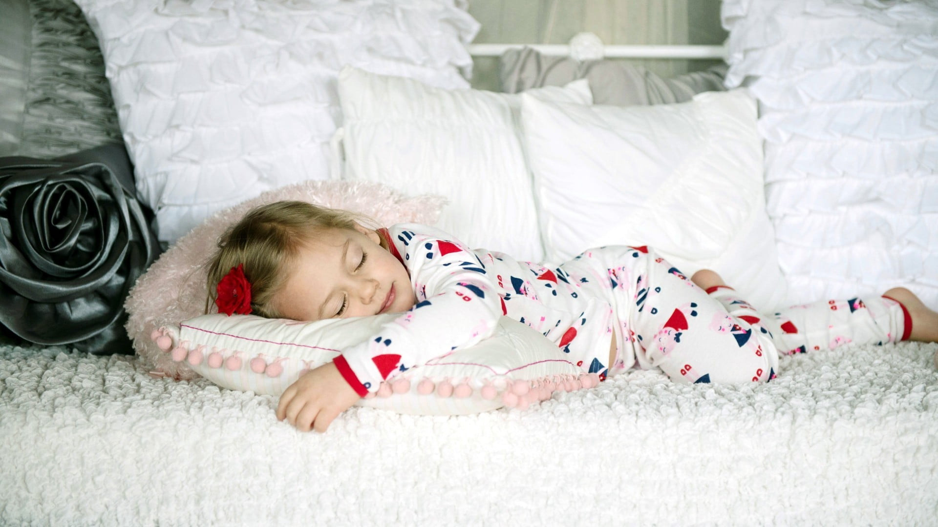 girl wearing pajamas sleeping on white bed