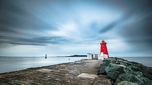 red lighthouse on concrete dock end, dublin, ireland