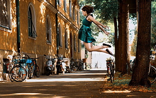 jumpshot photography of a woman wearing teal dress