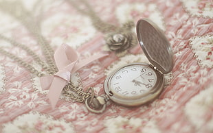 silver pocket watch with pink surface