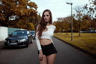woman wearing striped long-sleeved crop shirt and short shorts in middle of street