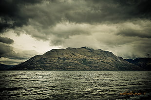 grayscale photo of hill near body of water, lake wakatipu