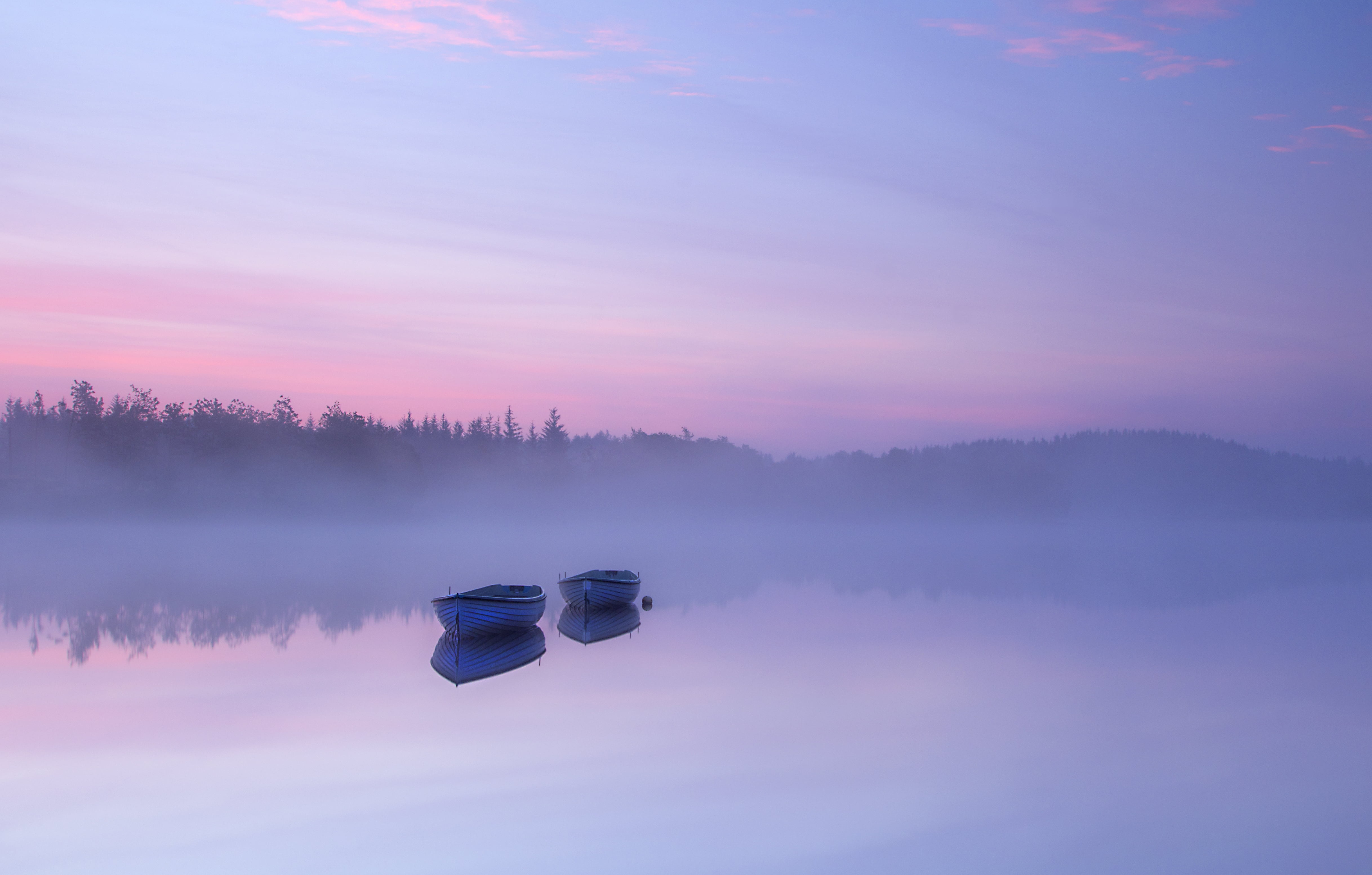 landscape photo of two jon boat on body of water surrounded by fogs under purple and pink sky
