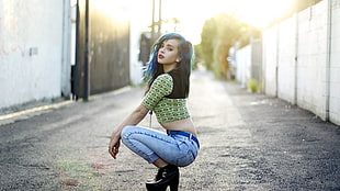 blue haired woman wearing yellow and black crop top and blue denim jeans