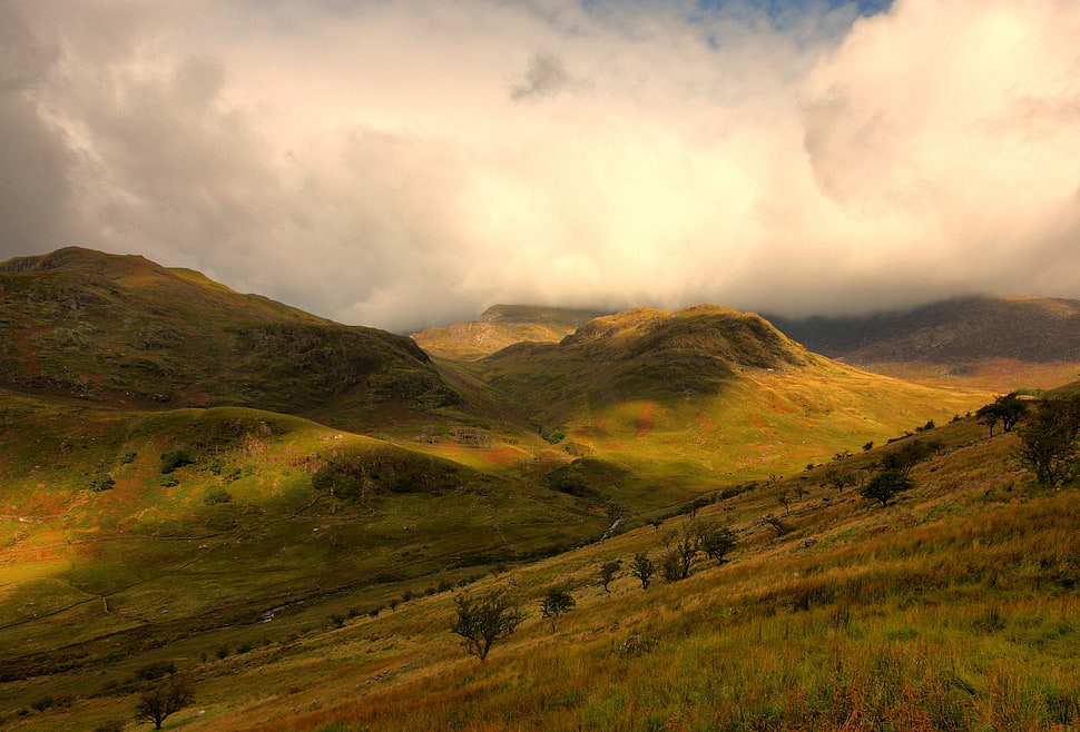 green mountains under cloudy sky at daytime HD wallpaper