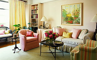 arranged sofa set, coffee table with painting on wall near shelf