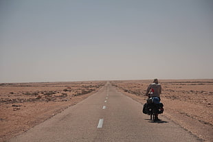 person riding motorcycle on road, bicycle, desert, road