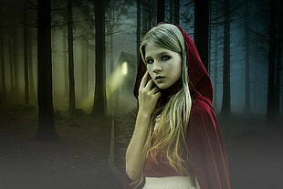 photo of woman wearing red hoodie with dark forest background