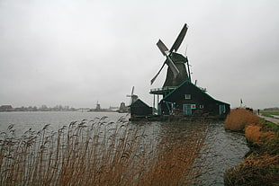 watermill near body of water during daytime