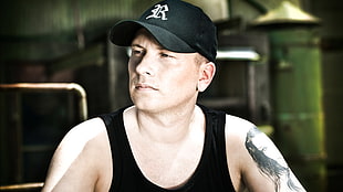 man in black fitted cap and black tank top with tattoo