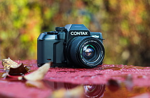 black Contax digital camera on red surface HD wallpaper