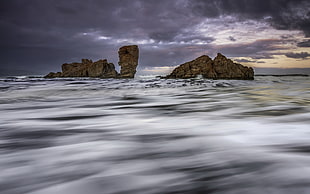 landscape photography of brown rocks surrounded by water