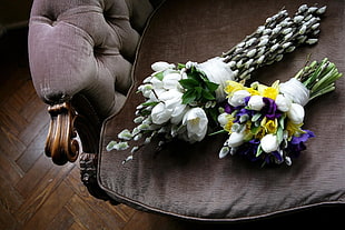 white, purple, and yellow petaled flower bouquet on brown surface